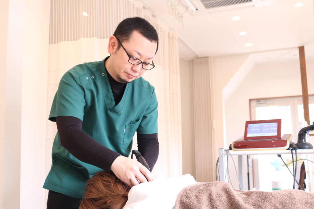 交通事故患者に超音波治療を行う交野市の整骨院スタッフ